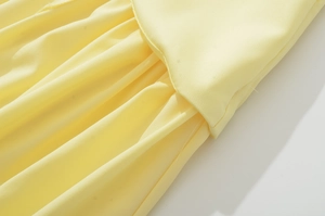 Vista macro del tessuto giallo con cuciture professionali e dettagli della trama fine