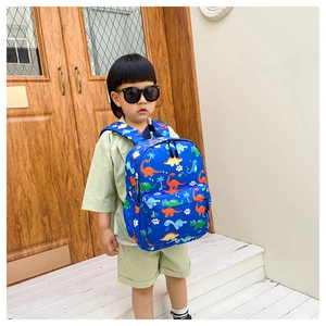 Detailed view of kids dinosaur backpack with blue cartoon print and dual zip pockets