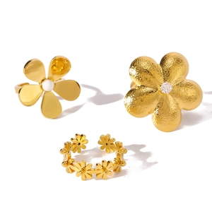 Gold stainless steel flower rings set with pearls and zircons on white background