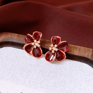 Macro detail of red flower earrings with 18K gold edges and crystal center studs