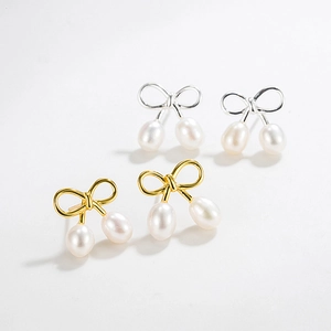 Boucles d'oreilles nœud avec perles d'eau douce baroques en or et argent sur fond blanc