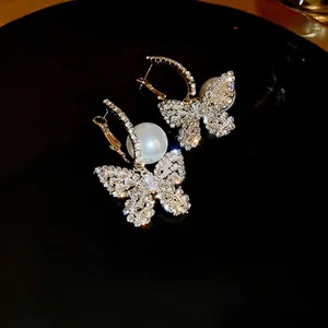 Elegant gold butterfly earrings with sparkling cubic zirconia and white faux pearls