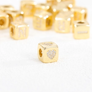 Detailed view of 18K gold plated cube bead with zircon heart inlay for DIY jewelry