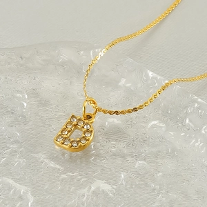Minimalist gold stainless steel D letter necklace with sparkling zircon crystals on white
