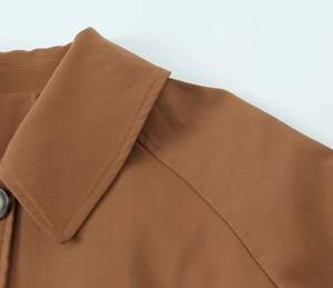 Detailansicht der Kragen- und Schulternähte an einem braunen langen Trenchcoat