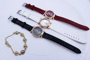 Close-up of rhinestone quartz watches with star dial and matching gold heart bracelet