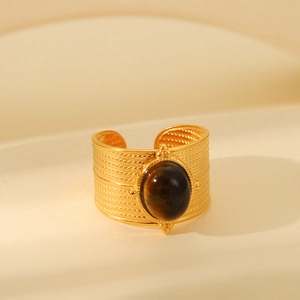 Close-up of a wide braided gold ring featuring a polished oval tiger eye gemstone