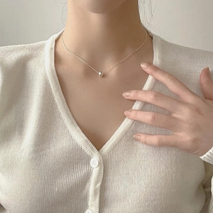 Detailed view of an 8mm minimalist 925 sterling silver ball necklace on female model
