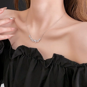 Close-up of elegant silver wheat ear necklace with cubic zirconia worn on a model's neck