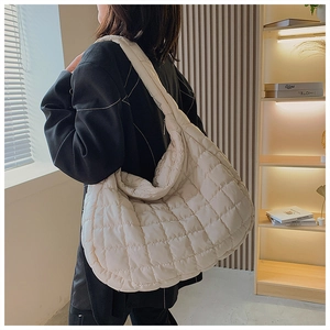Detail view of cream quilted puffer hobo bag showing its large capacity and soft texture
