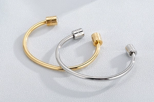 Detail of gold and silver open bangles with floral engraving and crystal studs