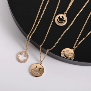 Minimalist gold plated smile pendant necklace with zircon crystals on a black display