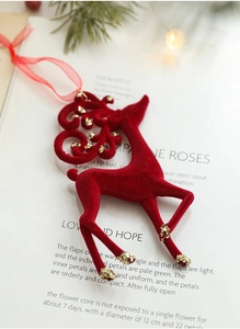 Close-up of red flocked Christmas reindeer ornament with gold sequins on magazine