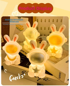 Macro view of four warm yellow rabbit astronaut night lights arranged on books