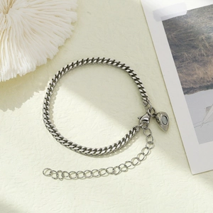 Detail of silver stainless steel Cuban chain bracelet with heart magnetic clasp