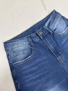 Dettaglio ravvicinato della cintura in denim blu scuro con cuciture gialle a contrasto