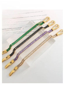 Close-up of luxury gold-plated bracelets featuring colorful zircon stones and buckle clasps