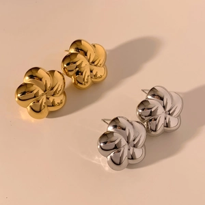 Macro detail of 3D hollow flower stud earrings in polished gold and silver finishes
