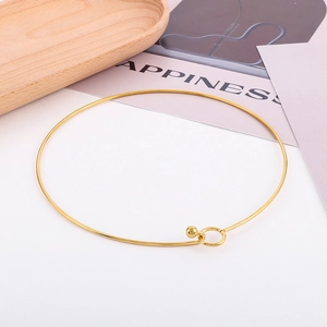 Primo piano di un choker dorato in acciaio inossidabile con chiusura a sfera e anello