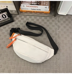 Close-up of white waterproof waist bag with orange zipper details and nylon strap