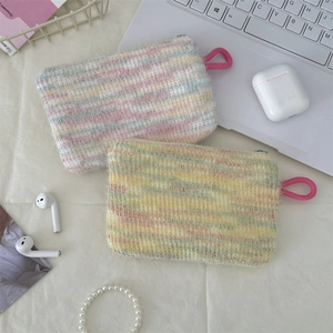 Flat lay of colorful striped plush coin purses with accessories in an aesthetic setup