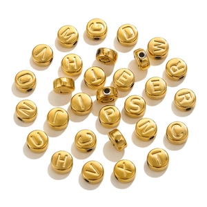 Macro detail of golden stainless steel alphabet beads for DIY jewelry making