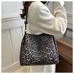 Detail of leopard print tote bag with knotted black strap and metal ring attachment