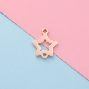 Vue macro d'un connecteur étoile en or rose pour bijoux DIY sur fond bicolore