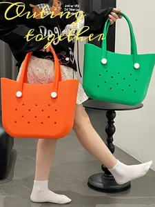 Detail of large waterproof EVA tote bags in bright orange and vibrant green with holes