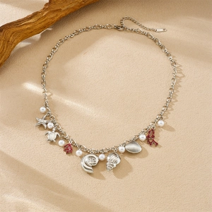 Golden sea life pendant necklace with starfish and coral on a sandy beach background