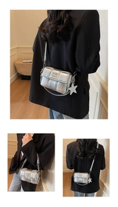 Détail d'un sac bandoulière tissé argenté avec breloque étoile et texture métallique