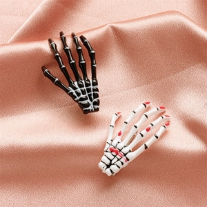 Gothic skull hand hair clips in black and bloody white on rose gold silk fabric