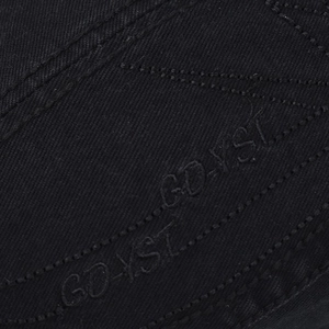 Macro view of black twill fabric featuring tonal GD-YST embroidery on a beret cap
