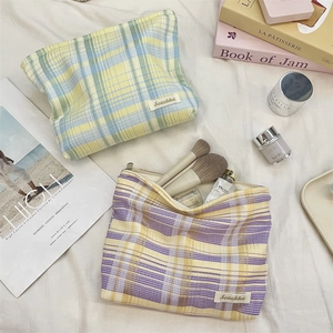 Detailed top view of open checkered cosmetic bags showing large interior capacity and brushes