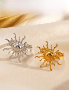 Detailansicht von Vintage Sonnenringen in Gold und Silber auf beigefarbenem Seidenstoff