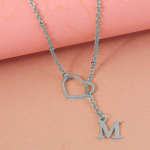 Detailed macro view of a silver stainless steel heart necklace with letter M pendant