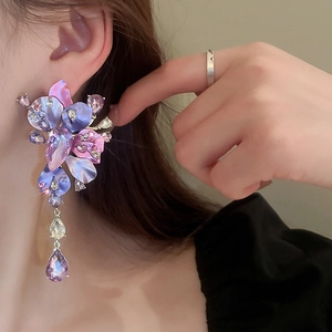 Macro shot of purple gradient flower earrings with rhinestones and crystal drop detail