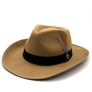 Close-up of khaki wool felt fedora with black ribbon, feather and vintage metal badge