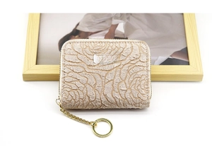 Detail of beige rose embossed coin purse with gold zipper and keyring chain