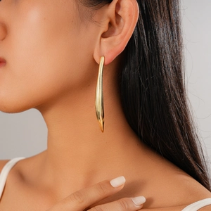 Détail d'une boucle d'oreille goutte d'eau minimaliste plaquée or 18 carats sur un modèle
