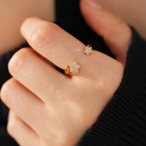 Gros plan d'une bague étoile en plaqué or 18k sertie de zircons sur un doigt féminin