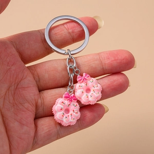 Close-up of pink donut keychain with colorful sprinkles and a pink ribbon bow detail