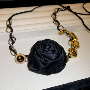 Dettaglio del choker rosa in raso nero con catena bicolore e ciondoli con perle vintage
