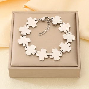 Detail of silver clover leaf link bracelet with adjustable chain on silk background