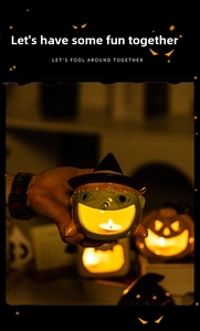 Detail of green ceramic ghost candle holder with a burning tea light for Halloween decor