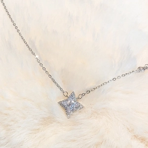 Macro shot of silver four-pointed star pendant necklace with shiny rhinestones detail