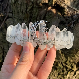 Natural crystal rainbow crown with metallic moon and star pendant on bark background