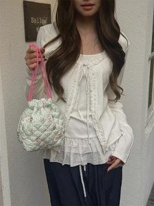 Quilted floral drawstring bucket bag shown in a street style view with soft lighting