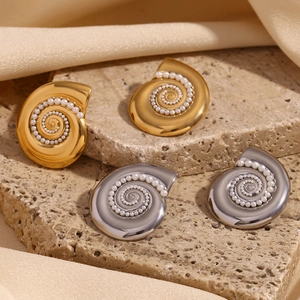 Detailed view of sea shell spiral earrings featuring elegant white pearls and polished metal