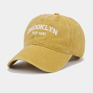Detail of mustard yellow washed cotton baseball cap with white Brooklyn embroidery